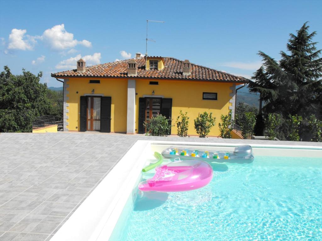 a house with a swimming pool with a pink inflatable at Casa Caldesi in Castiglion Fiorentino