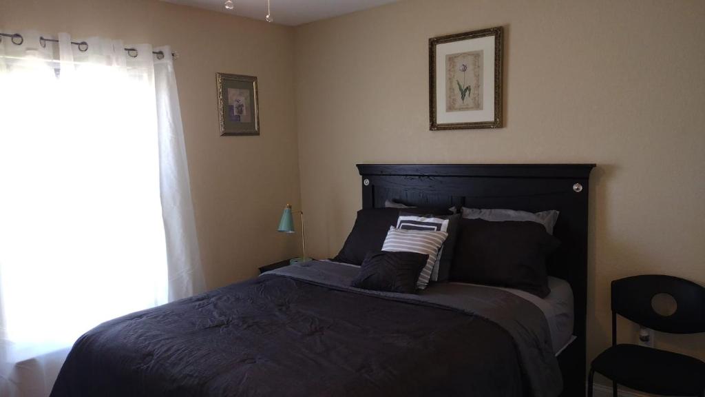 a bedroom with a black bed with a window at The Orchard Suite of Sebring in Sebring