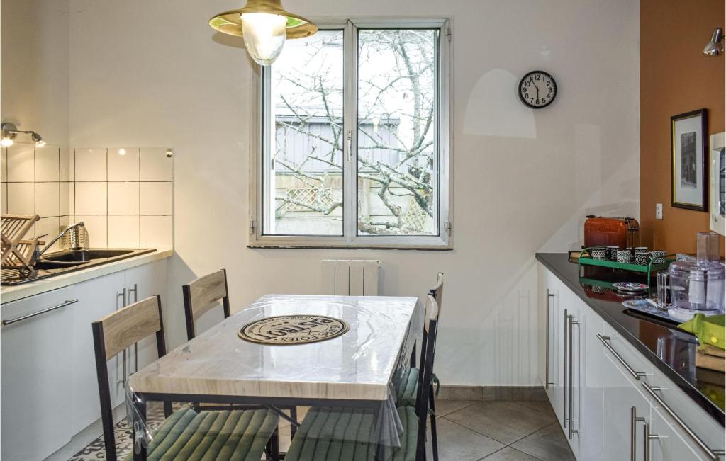 a kitchen with a table and chairs and a window at Awesome Home In Paimpol With Kitchen in Paimpol