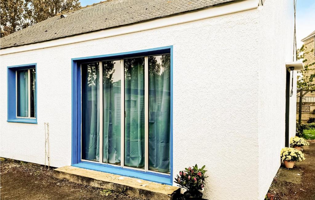 a house with blue windows on the side of it at Awesome Home In Paimpol With Kitchen in Paimpol