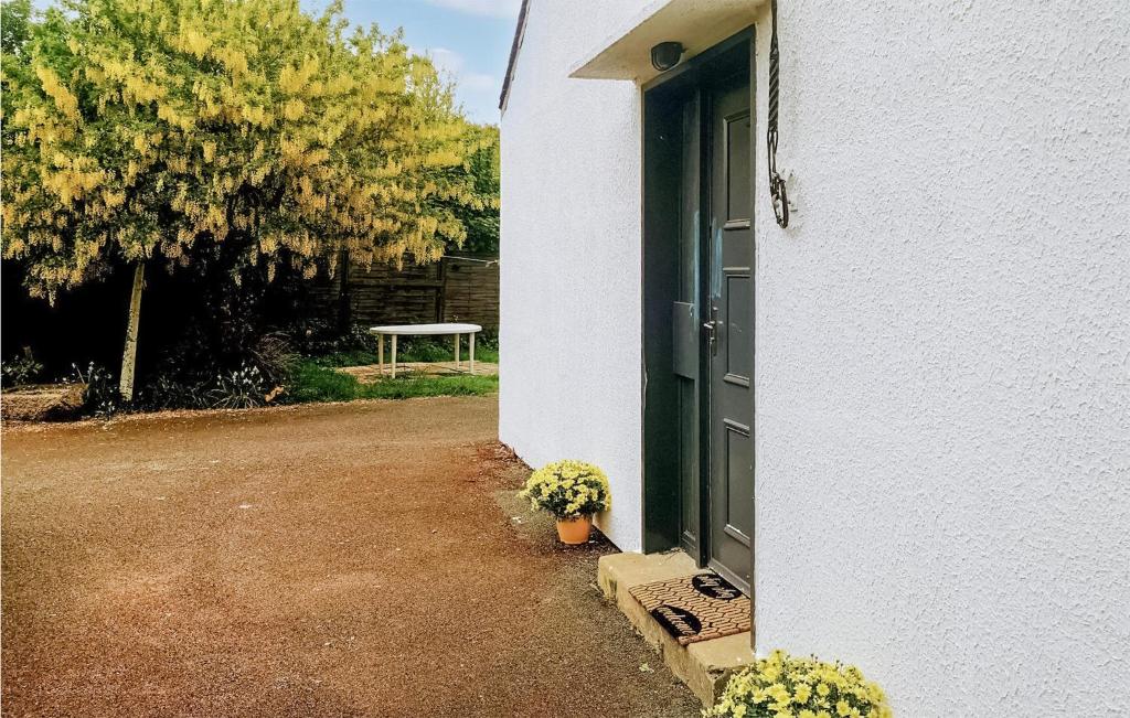 a green door on a white house with a table at Awesome Home In Paimpol With Kitchen in Paimpol