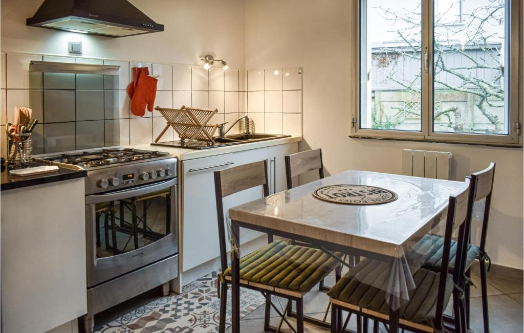 a kitchen with a table and a stove at Awesome Home In Paimpol With Kitchen in Paimpol