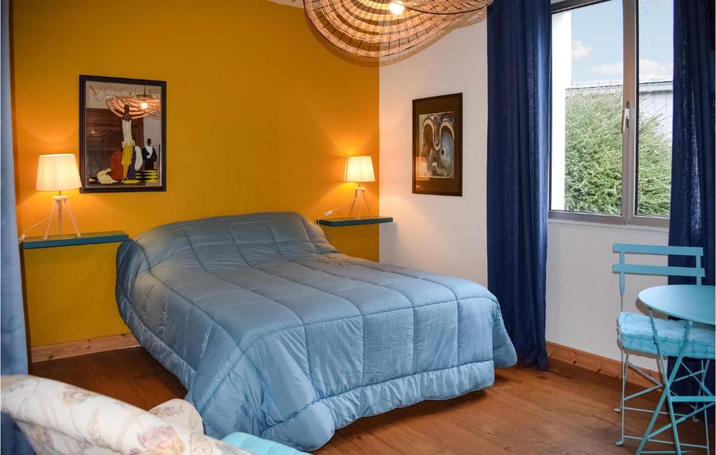 a bedroom with a blue bed in a yellow wall at Awesome Home In Paimpol With Kitchen in Paimpol