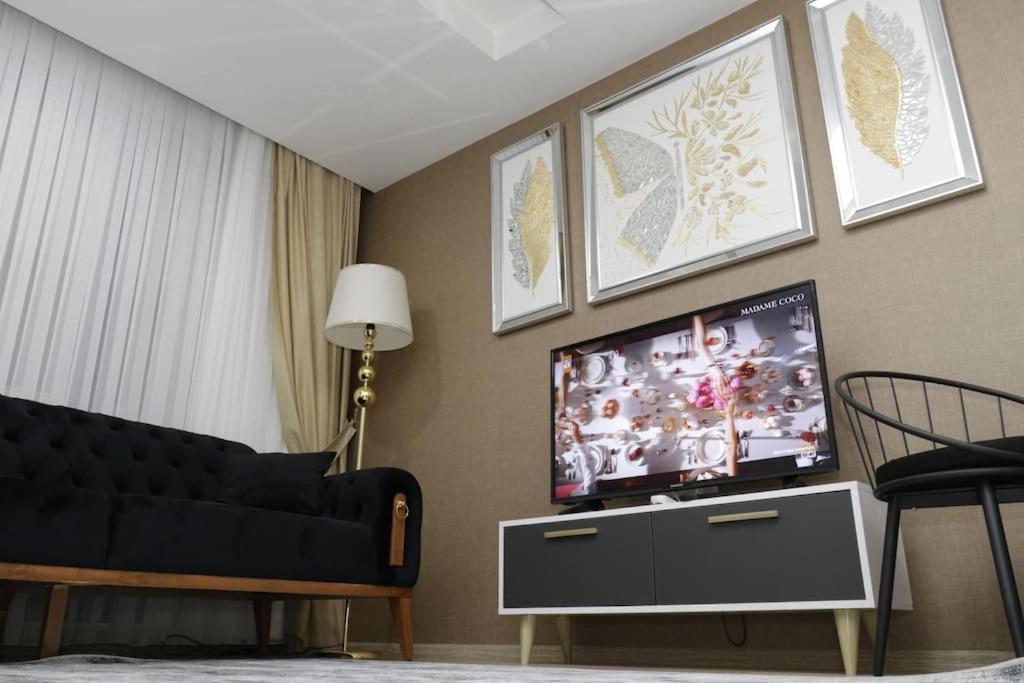 een woonkamer met een bank en een flatscreen-tv bij Fully Equipped Apartment Istanbul (Zarif26) in Avcılar