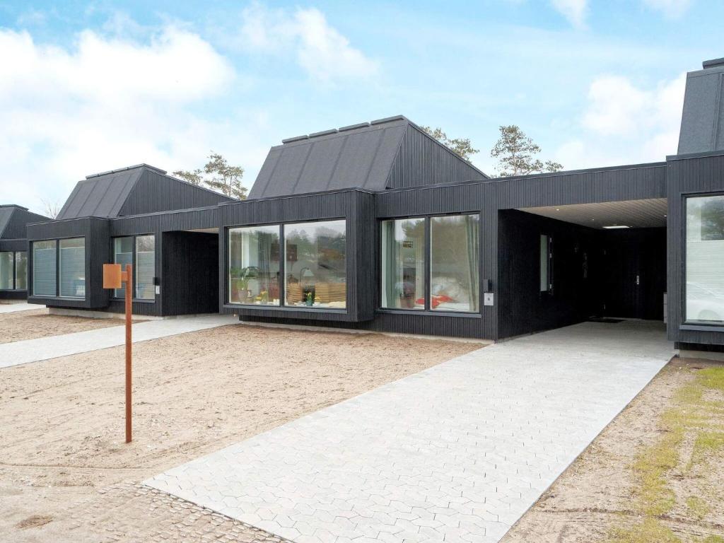 une maison noire avec beaucoup de fenêtres dans l'établissement Holiday home Gilleleje VII, à Gilleleje