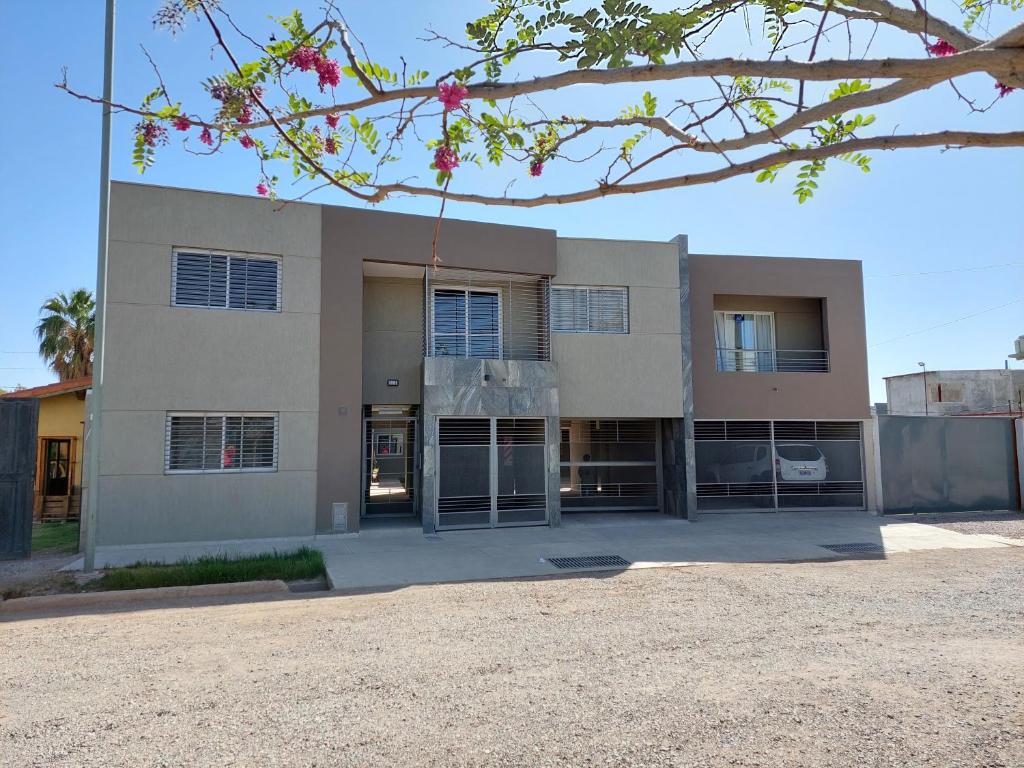 een groot wit gebouw met een boom ervoor bij ALTOURQUIZA8 in Guaymallen