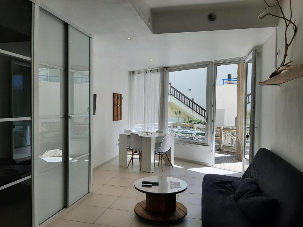 salon ze stołem i kanapą w obiekcie Appartement cosy avec jardin près du port et des plages à Capbreton - FR-1-239-905 w mieście Capbreton