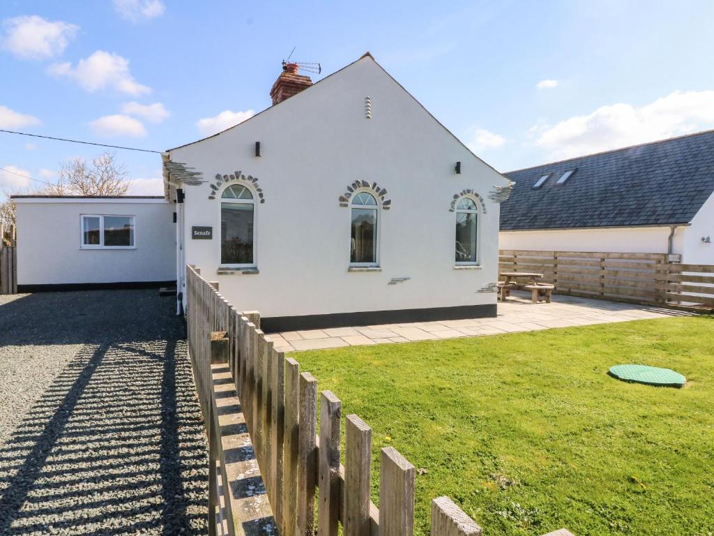 a white house with a fence and a frisbee at Senafe in Bude