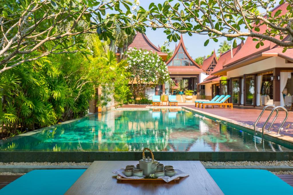 a pool with a table in front of a house at Baan Tao Talay - by Sublime Samui Villas in Lipa Noi
