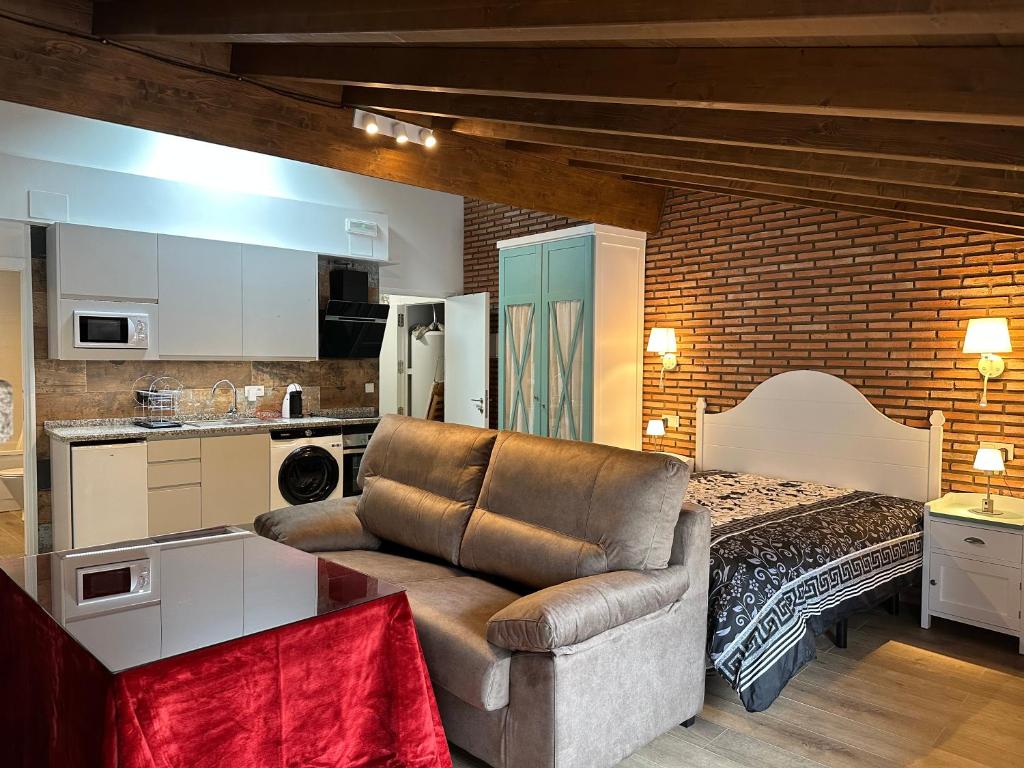uma sala de estar com um sofá em frente a uma cozinha em Apartamentos A Fala en Trevejo y San Martin de Trevejo, Sierra de Gata em Trevejo