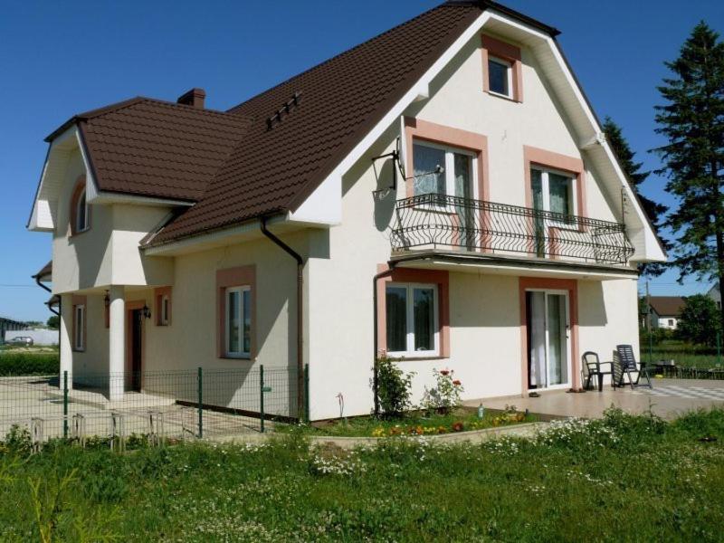 Family Homes - Bed & Bike Guesthouse في Łebcz: منزل أبيض كبير على سقف أسود