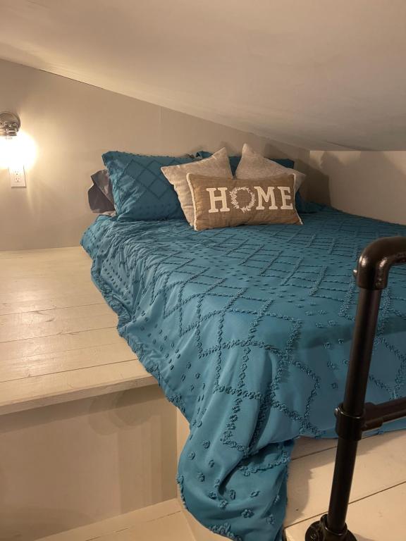 1 cama con edredón azul en una habitación en Delightful Tiny Home w/ 2 beds and indoor fireplace, en McKinleyville
