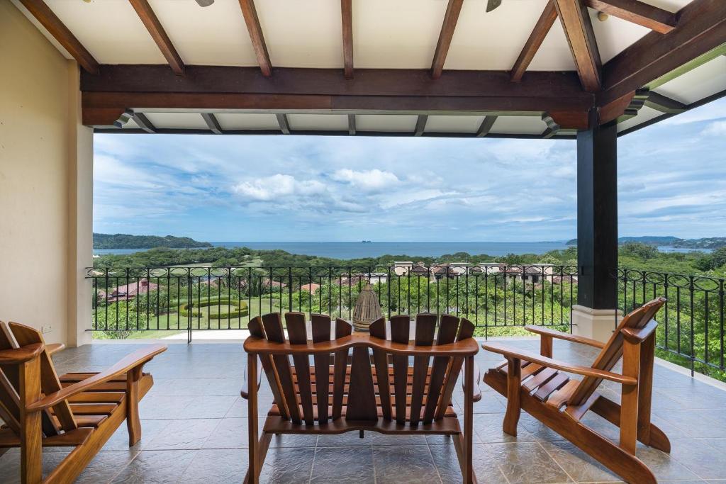 Habitación con mesa, sillas y ventana grande. en Malinche 423-B, Ocean View 2 BR Condo at Reserva Conchal, en Brasilito