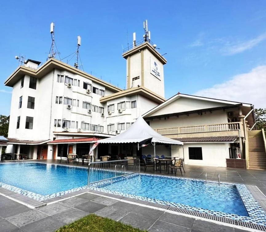 een groot gebouw met een zwembad ervoor bij Myangkasa Akademi & Resort Langkawi in Pantai Cenang