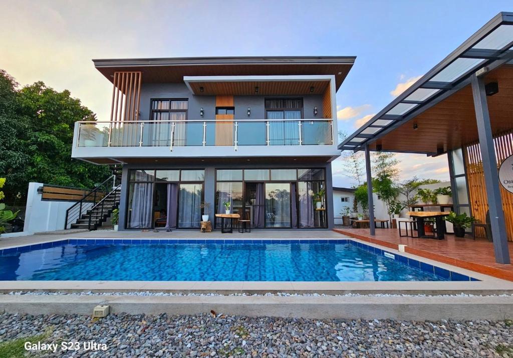 una casa con piscina frente a una casa en Obra Maestro Private Resort, en Lubao