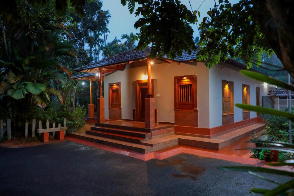 a small house with a pathway leading to it at Kudajadri Heritage Homestay in Kaniyāmbetta