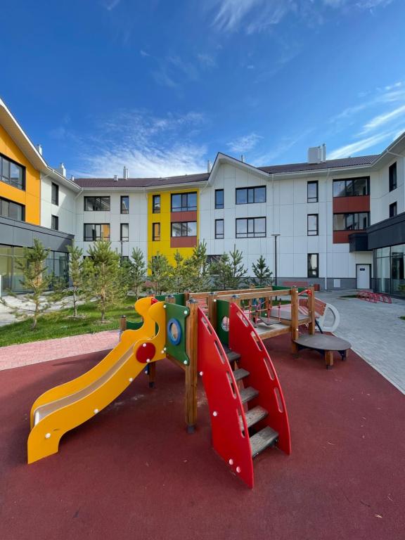 a playground with a slide in front of a building at Promenade Burabay halal-apartments (no alcohol, no unmarried couples)) in Borovoye