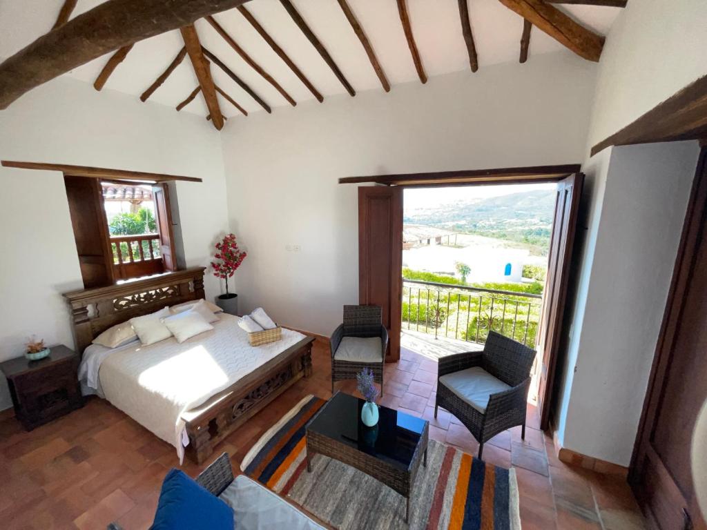 a bedroom with a bed and a large window at Casa campestre mediterraneo in Barichara