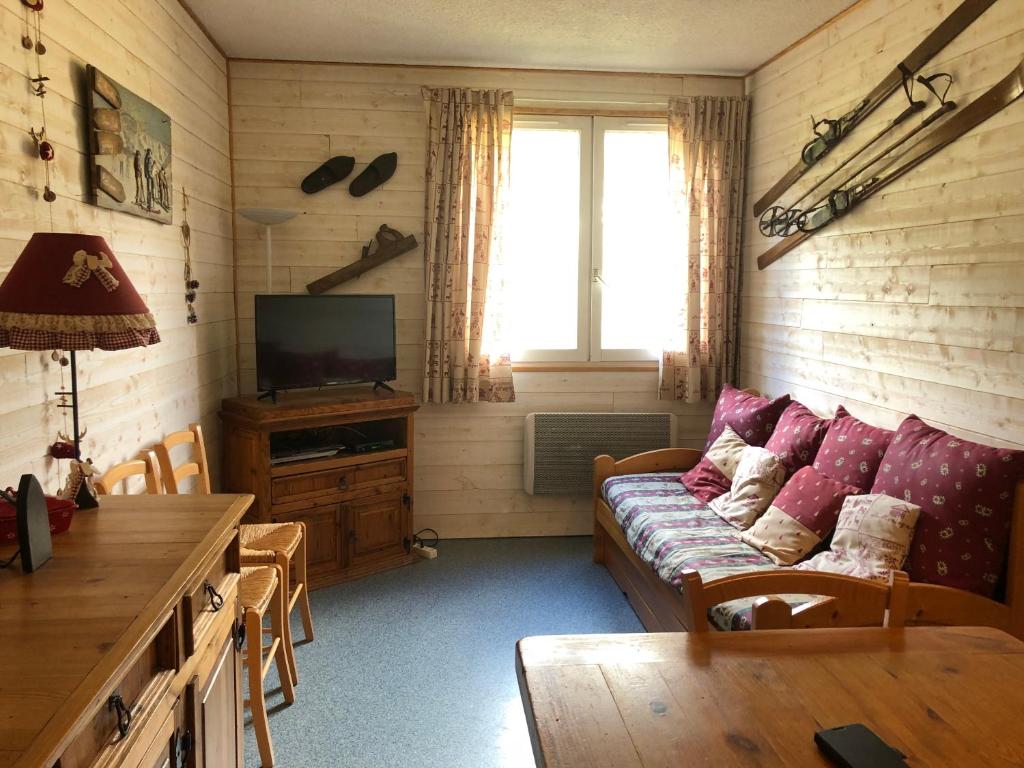 a living room with a couch and a tv at Le Bois des Lièvres in Saint-Pierre-de-Chartreuse