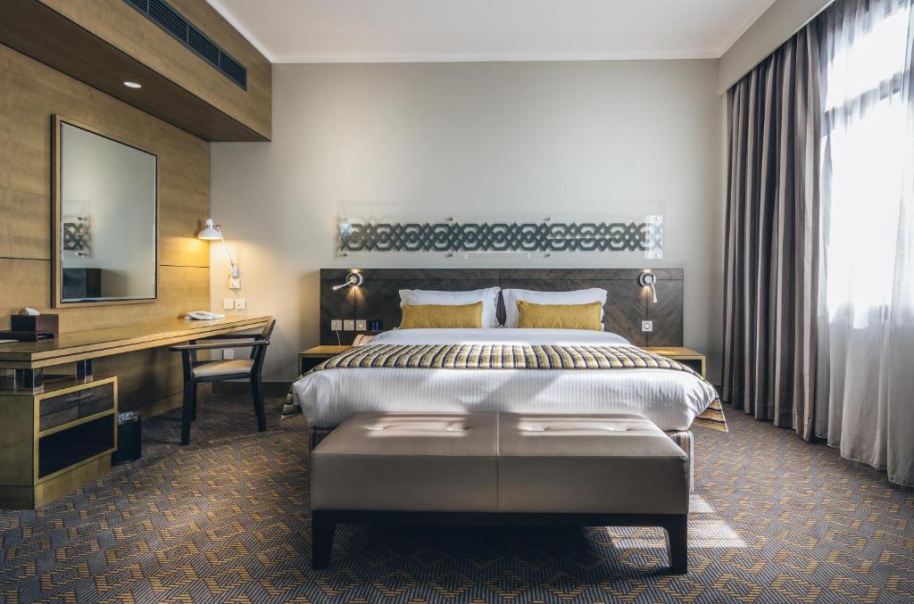 a hotel room with a bed and a desk at Ayla Bawadi Hotel & Mall in Al Ain