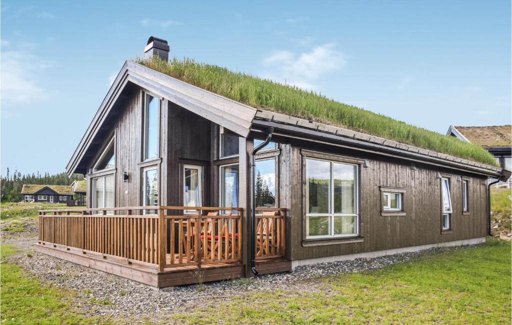 a house with a grass roof with a large deck at Beautiful Home In Lillehammer With Sauna in Lillehammer