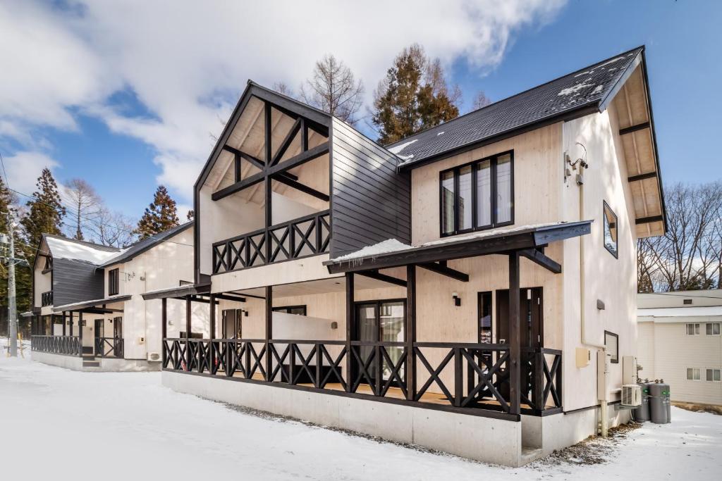 an exterior view of a house with a black roof at HOPETREE HAKUBA in Iida