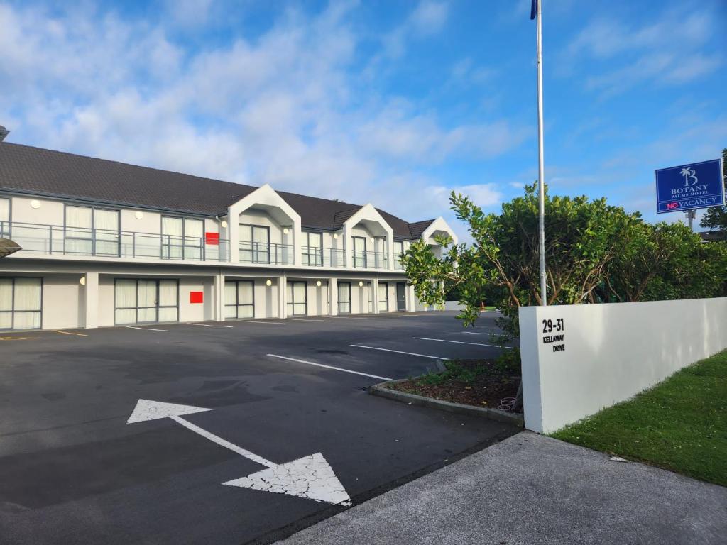 un parcheggio vuoto di fronte a un edificio di Botany Palms Motel ad Auckland