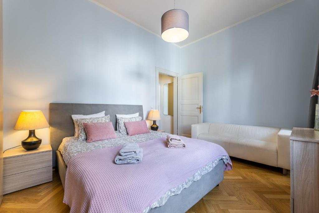 sypialnia z dużym łóżkiem z różowymi poduszkami w obiekcie Big bright two-bedroom apartment in Prague Old Town w Pradze