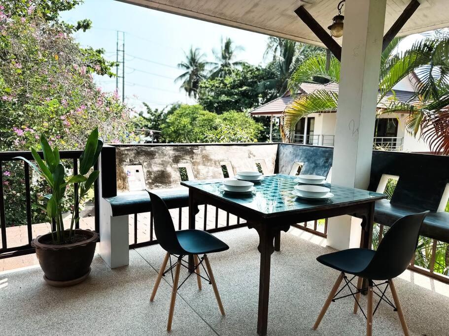 una mesa y sillas en el balcón de una casa en SID house en Ban Hua Laem Ma So
