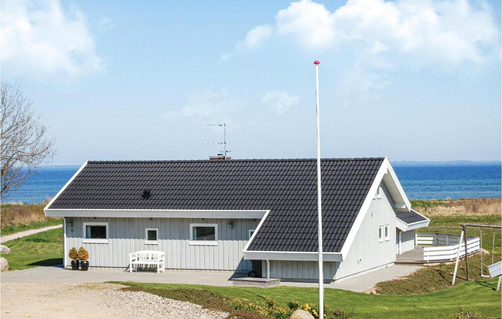 ノーポにあるBeautiful Home In Nordborg With 3 Bedrooms, Sauna And Wifiの海を背景にした白い家