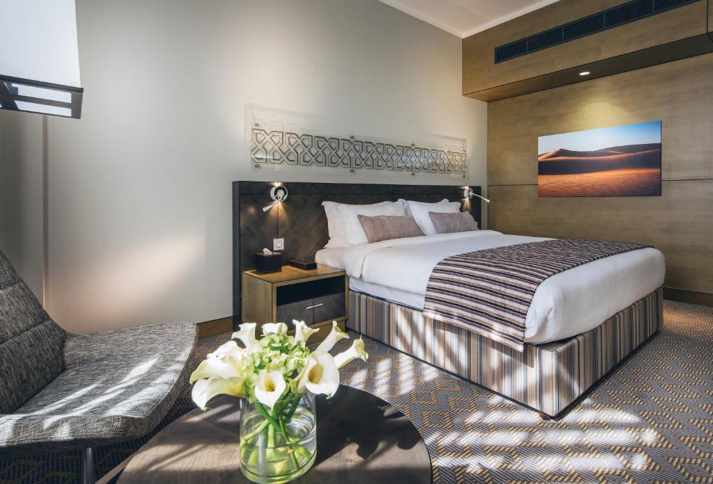 a hotel room with a bed and a couch at Ayla Bawadi Hotel & Mall in Al Ain