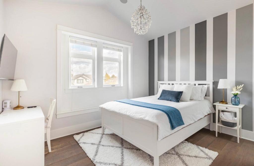 a white bedroom with a bed and a window at Vancouver West Cozy Retreat by Host Launch in Vancouver