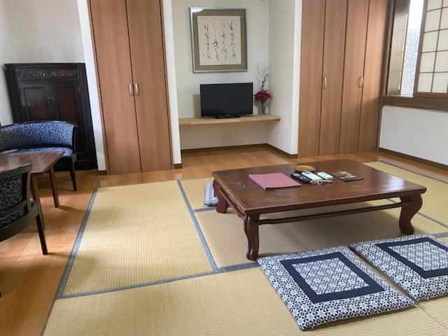 uma sala de estar com uma mesa de centro e uma televisão em 湯布院 おやど花の湯yufuin oyado hananoyu em Yufu