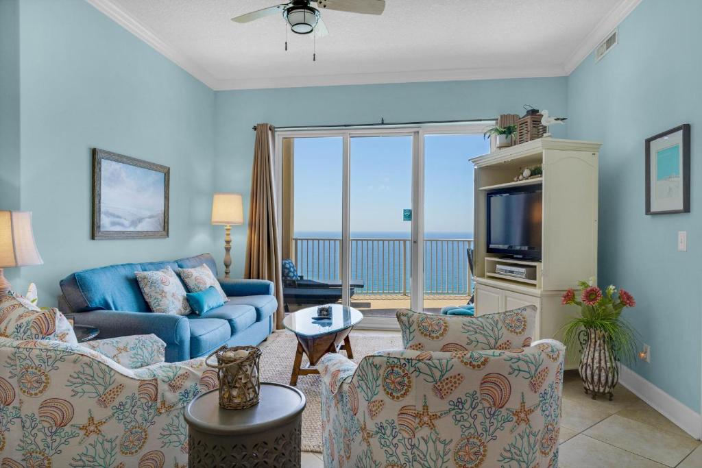 a living room with a couch and a tv at Ocean Villa Penthouse #2302 in Panama City Beach