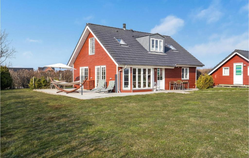 uma casa vermelha com um pátio e um quintal em Beautiful Home In Frrup With Kitchen em Tårup