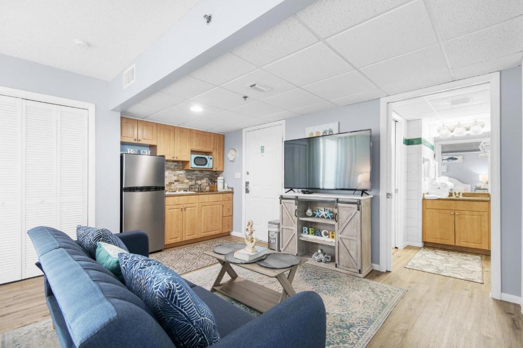 ein Wohnzimmer mit einem blauen Sofa und einer Küche in der Unterkunft Long Beach Resort 1-1300E in Panama City Beach
