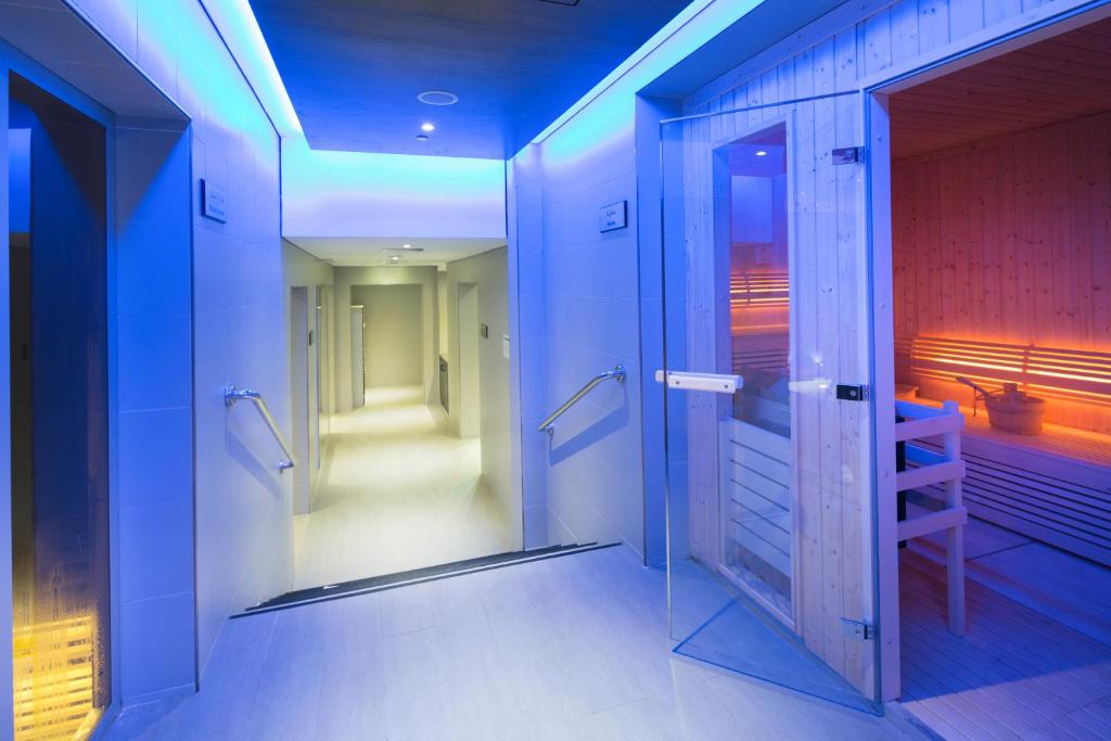 a bathroom with a walk in shower and a glass door at Ayla Bawadi Hotel & Mall in Al Ain