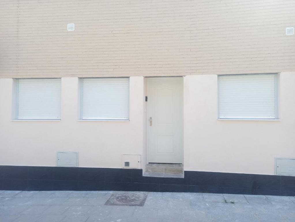 a white building with four windows and a door at MINI ESTUDIOS SANSE in San Sebastián de los Reyes