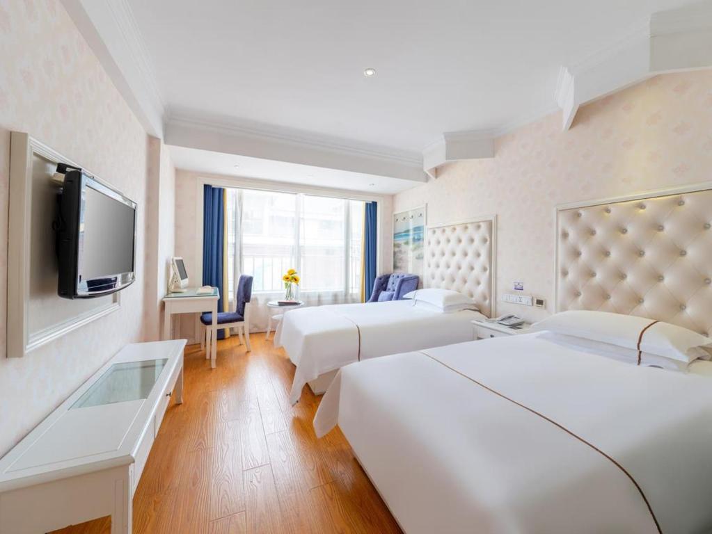 een hotelkamer met 2 bedden en een flatscreen-tv bij Lingshang Hotel in Yiwu