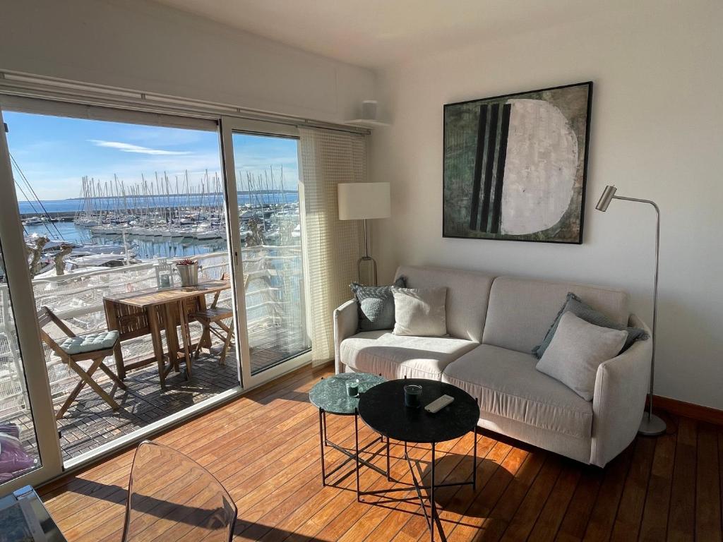 a living room with a couch and a large window at Le Petit Pinson Meerblick Port Golfe Juan in Vallauris