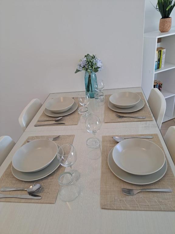 a dining table with plates and wine glasses on it at AFRODITI APARTMENTs in Perivolia