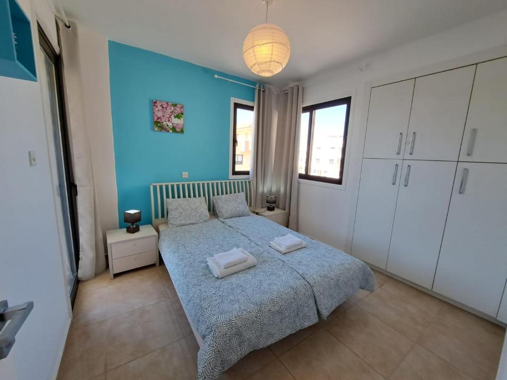 a bedroom with a bed and a blue wall at AFRODITI APARTMENTs in Perivolia