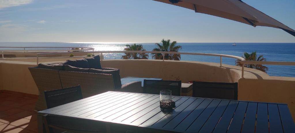 - stół i krzesła na balkonie z widokiem na ocean w obiekcie El Mirador de Estepona w mieście Estepona