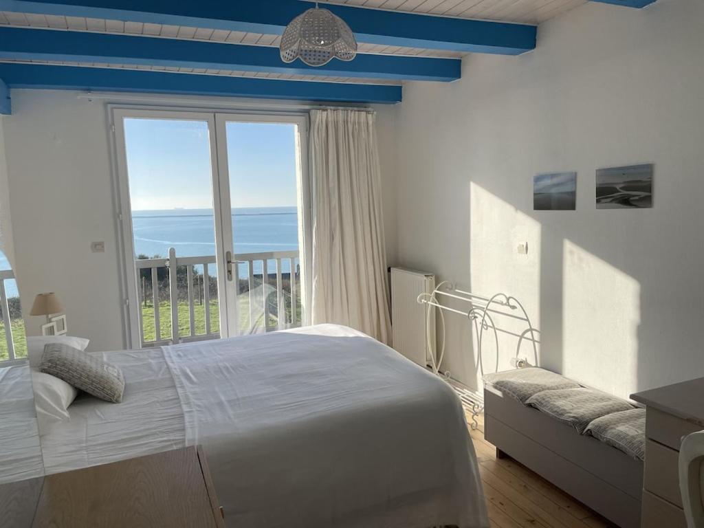 sypialnia z łóżkiem i dużym oknem w obiekcie Villa face mer aux magnifiques couchers de soleil 5 mn de Nausicaa w mieście Boulogne-sur-Mer