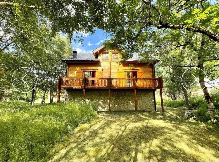 ein Holzhaus mit einer Terrasse auf einem Hof in der Unterkunft Chalet chaleureux l’hospitalet près l’andorre . in LʼHospitalet-près-lʼAndorre