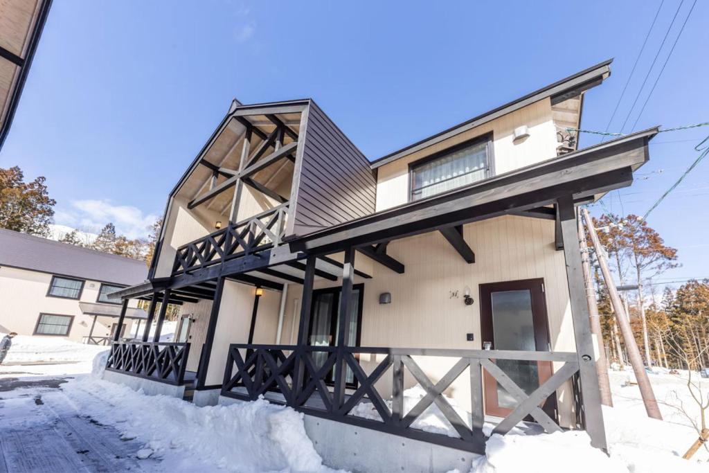 a house with a black and white facade in the snow at WHITE HAKUBA in Iida