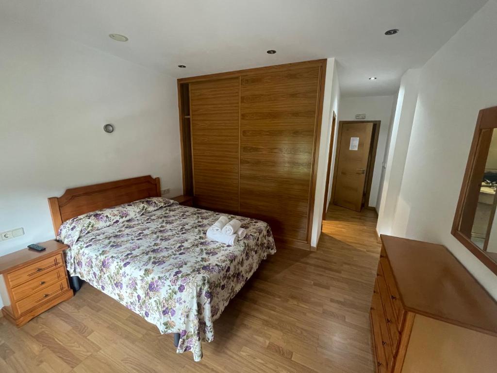 een slaapkamer met een bed en een houten muur bij Camiño Portugues in Padrón