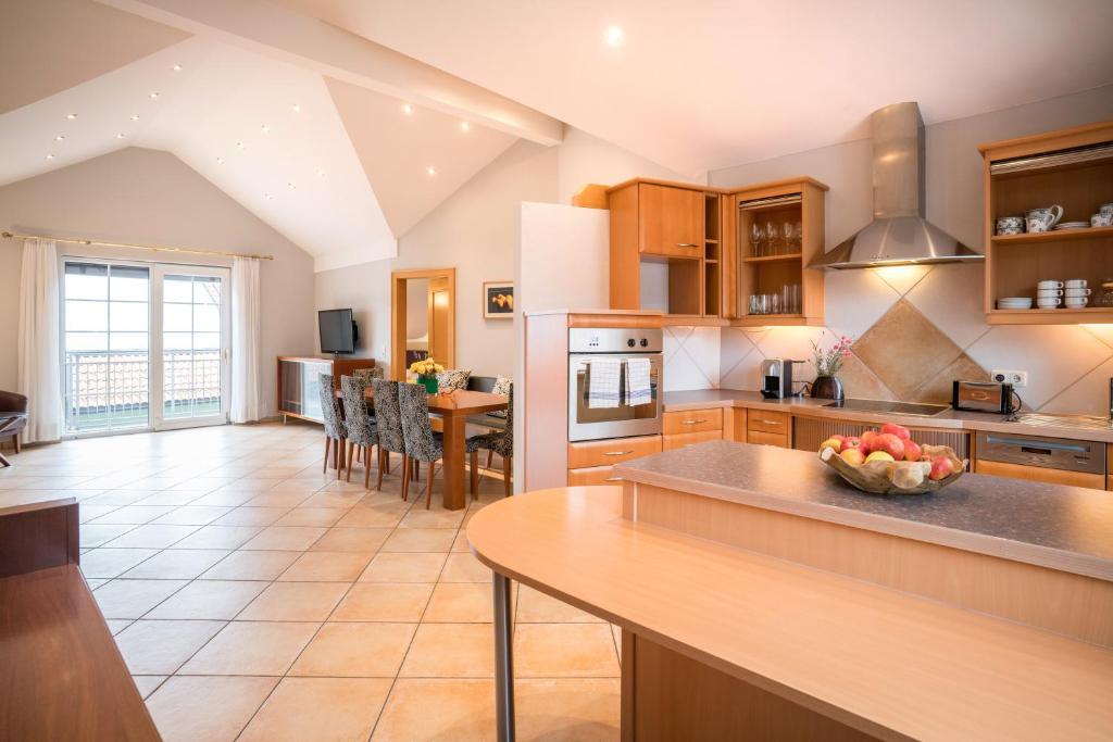 a large kitchen with a counter and a table at Holiday Apartments by Das Grüne Hotel zur Post - 100 % BIO & Villa Ceconi in Salzburg