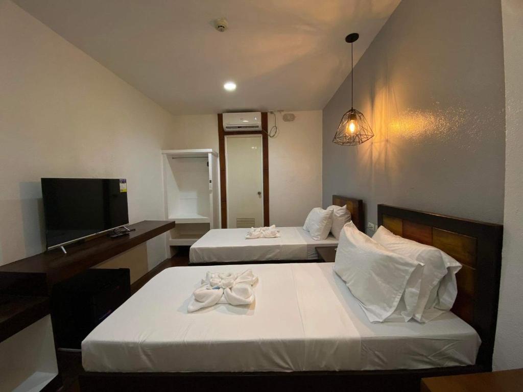 Postel nebo postele na pokoji v ubytování Dumaguete Seafront Hotel