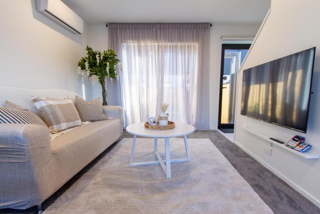 sala de estar con sofá y mesa en Stylish 2-Bedroom Haven Next to Hagley Park en Christchurch